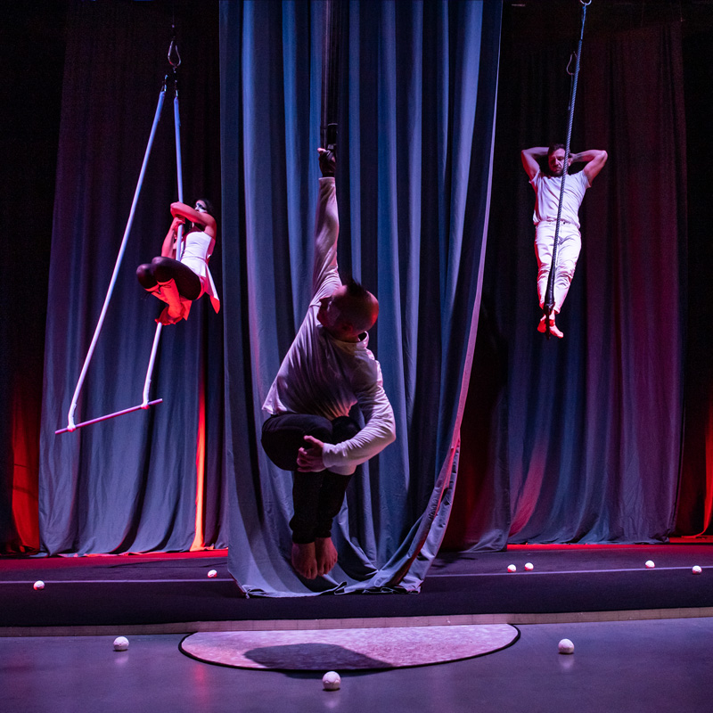 Three aerialists perform during That Which Lights Your Way: Reflection, by Breaking Circus.